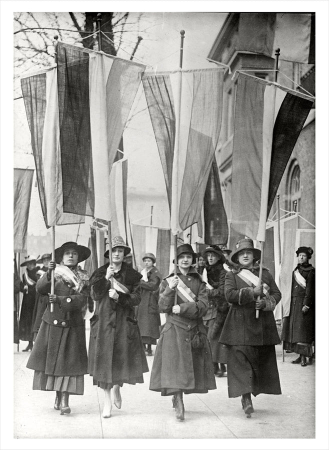 Black and white photo of suffragette holding flags