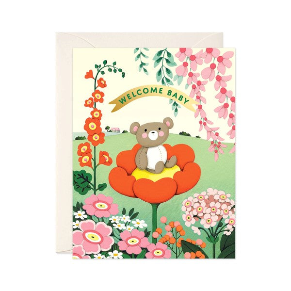 Teddy bear sitting in flower welcoming card